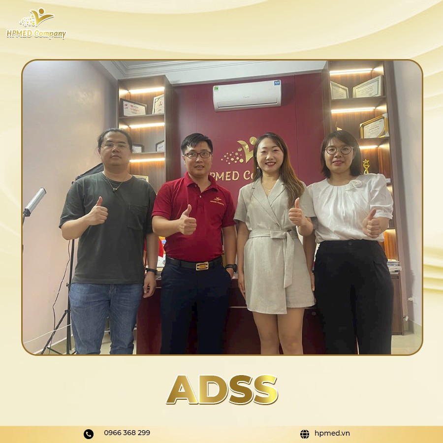 Nhân viên HPMED Company chụp ảnh tại văn phòng, đứng trước quầy lễ tân thương hiệu HPMED Company